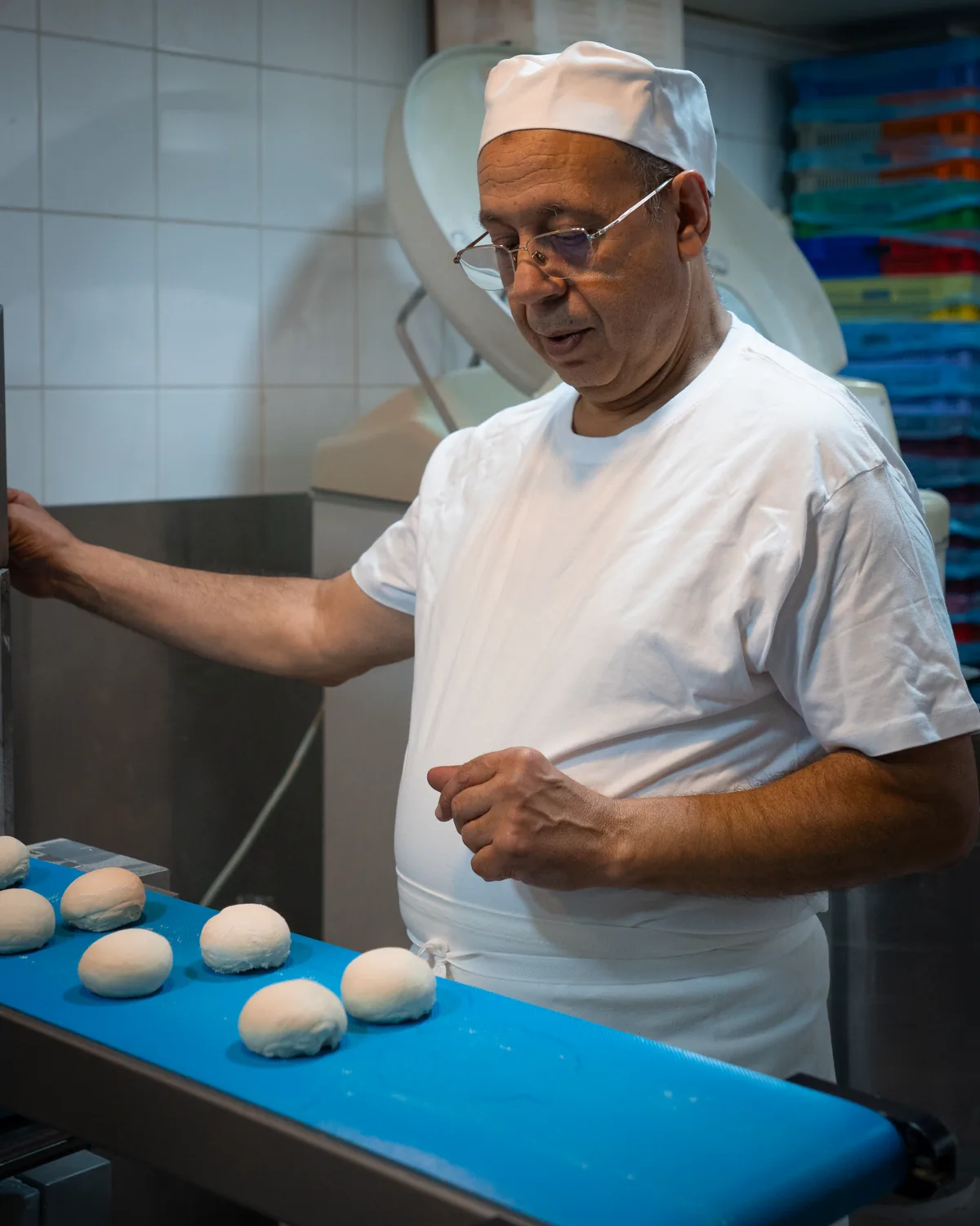 Jamal Ahlaloum surveille les pâtons de pain burger qui avancent sur le tapis