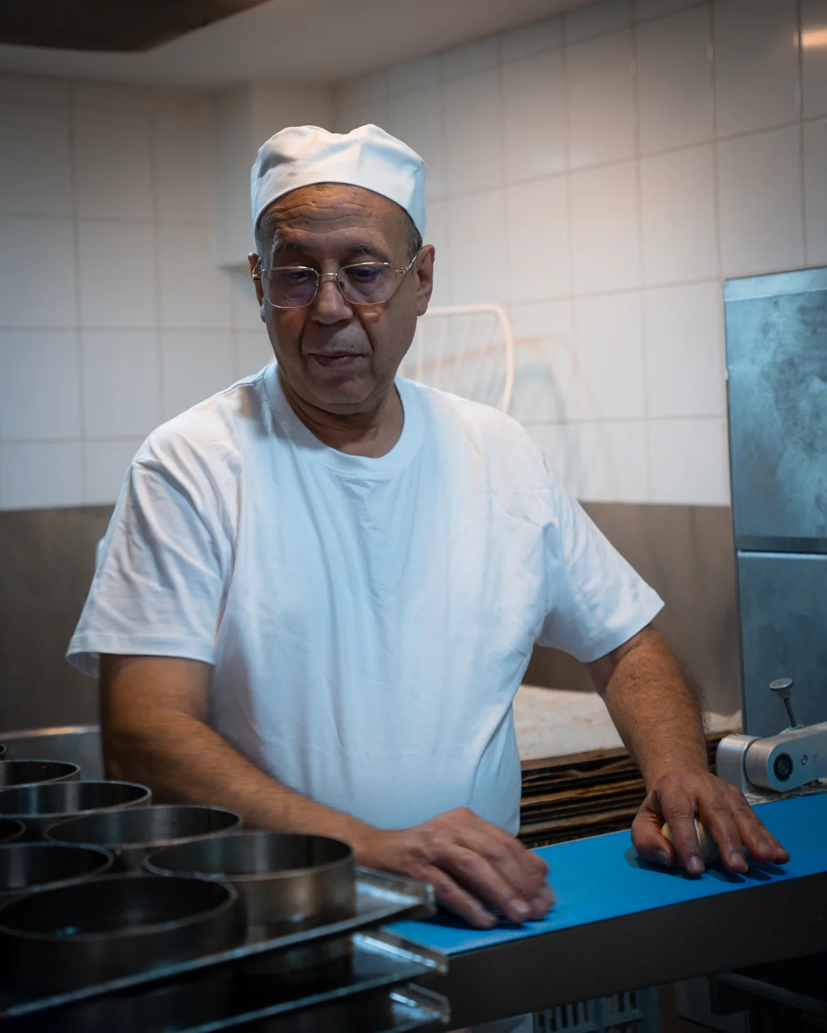 Jamal Ahlaloum au plan de travail du fournil, les moules alignés à côté de lui